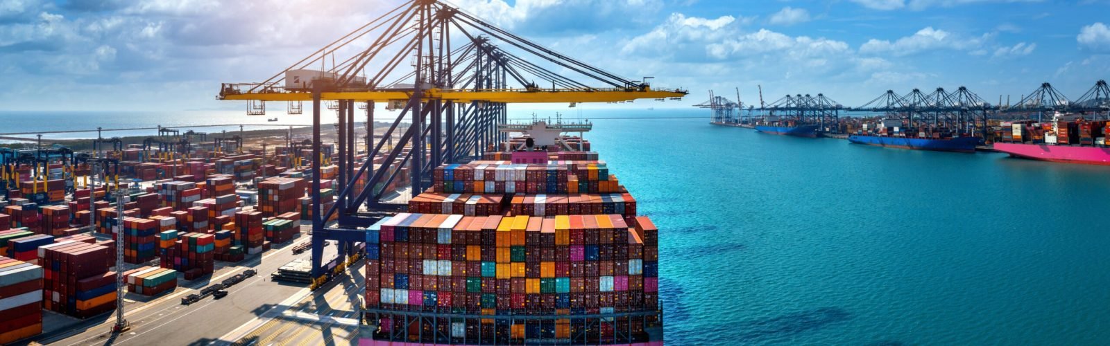 Aerial view of cargo ship and cargo container in harbor.